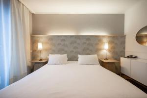 Cama ou camas em um quarto em Hotel Les Arcades