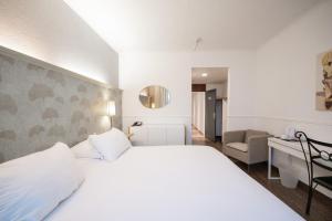 Cama ou camas em um quarto em Hotel Les Arcades