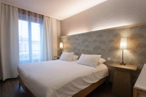Cama ou camas em um quarto em Hotel Les Arcades