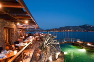 a restaurant with a bridge over a body of water at Grand Resort Lagonissi in Lagonissi