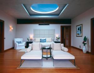 a living room with white furniture and a blue ceiling at Grand Resort Lagonissi in Lagonissi +68 photos