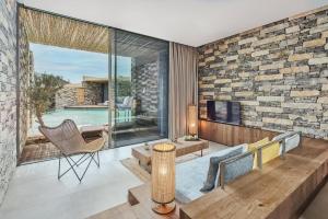 a living room with a stone wall at Voyage Torba Hotel in Torba