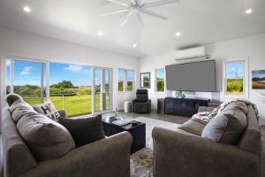 a living room with two couches and a flat screen tv at Haupu Hale at Poipu in Koloa