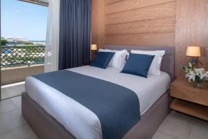 a bedroom with a large bed with a large window at Nana Golden Beach All Inclusive Resort & Spa in Hersonissos +284 photos