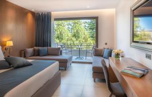 赫索尼索斯Nana Golden Beach All Inclusive Resort & Spa的一间卧室，里面有一张床、一张沙发和一张桌子