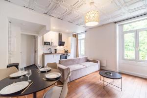 una sala de estar con una mesa, sillas y un sofá en Hôtel Lefort - Le Cocon Harmonieux, en Guingamp