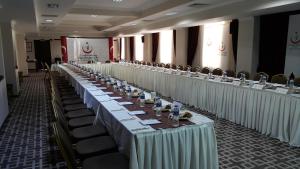 una fila di tavoli e sedie in una stanza di Grand Cali Hotel a Bozuyuk