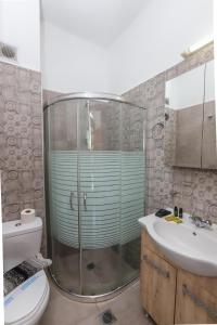 ein Badezimmer mit Dusche, Toilette und Waschbecken in der Unterkunft BELVITA Hotel in Kolymbia