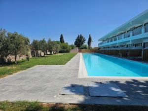 ein großes Schwimmbecken neben einem Gebäude in der Unterkunft BELVITA Hotel in Kolymbia