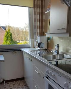 uma cozinha com um lavatório e um fogão forno superior em FeWo Machedanz Timmendorfer Strand em Timmendorfer Strand