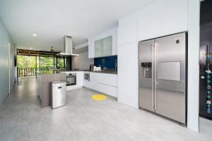 a kitchen with stainless steel appliances and white cabinets at Bangtao Beach Garden - 2 BR Apartment in Ban Lum Fuang
