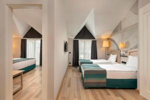 two beds in a hotel room with white walls at Greenwood Kemer Resort in Kemer +69 photos