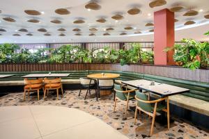a restaurant with tables and chairs and plants at Greenwood Kemer Resort in Kemer