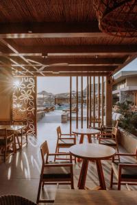 a group of tables and chairs on a patio at Unique Blue! Resort and Villas Adults Only in Karteros