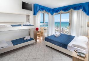 a bedroom with two beds and a balcony with the ocean at Hotel Lido in Gabicce Mare +71 photos