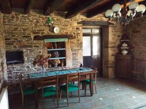comedor con mesa de madera y sillas verdes en Casa Grande de Anllo, en Sistallo