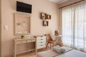 a bedroom with a desk and a dresser with a mirror at Filoxenia Apartments in Mytilene