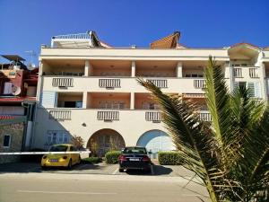 budynek z dwoma samochodami zaparkowanymi przed nim w obiekcie BEACH APARTMENT SVETI FILIP JAKOV - with PRIVATE PARKING w mieście Sveti Filip i Jakov