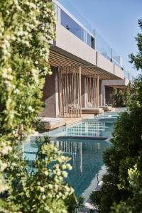a building with a swimming pool in front of it at NEMA Design Hotel & Spa - Small Luxury Hotels of the World in Hersonissos
