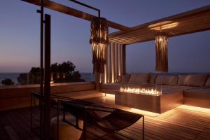 a living room with a couch and a fireplace at NEMA Design Hotel & Spa - Small Luxury Hotels of the World in Hersonissos