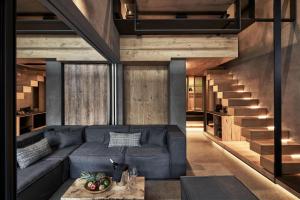 a living room with a blue couch and a staircase at NEMA Design Hotel & Spa - Small Luxury Hotels of the World in Hersonissos