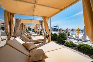 a patio with couches and chairs and a pool at Arena Grand Kazela Camping Homes in Medulin