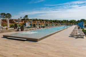 a swimming pool at a resort with tables and chairs at Arena Grand Kazela Camping Homes in Medulin