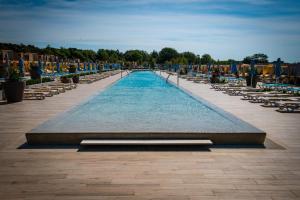 a swimming pool with chairs and a fountain at Arena Grand Kazela Camping Homes in Medulin