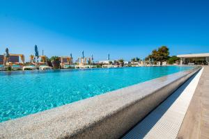 a swimming pool with blue water in a resort at Arena Grand Kazela Camping Homes in Medulin