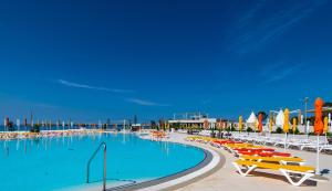 a large swimming pool with lounge chairs and umbrellas at Arena Grand Kazela Camping Homes in Medulin
