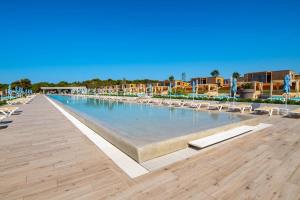 a swimming pool at a resort with lounge chairs at Arena Grand Kazela Camping Homes in Medulin
