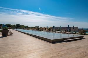 a large swimming pool with chairs and umbrellas at Arena Grand Kazela Camping Homes in Medulin