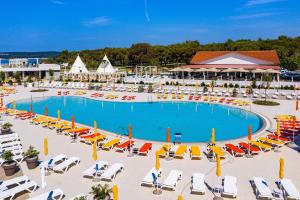 an overhead view of a large swimming pool with chairs and lawn chairs at Arena Grand Kazela Camping Homes in Medulin