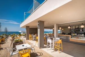 a restaurant with yellow chairs and tables and a bar at Arena Grand Kazela Camping Homes in Medulin