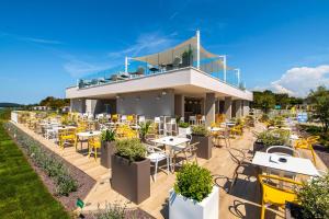 a restaurant with tables and chairs in front of a building at Arena Grand Kazela Camping Homes in Medulin