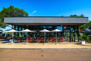 a restaurant with tables and chairs and umbrellas at Arena Grand Kazela Camping Homes in Medulin