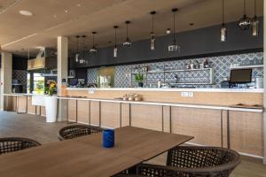 a restaurant with a table and chairs and a bar at Arena Grand Kazela Camping Homes in Medulin