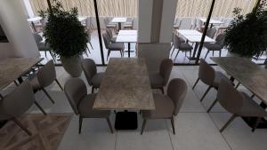 Un comedor con mesas, sillas y espacios para mesas. en Q Ella Beach Hotel, en Side