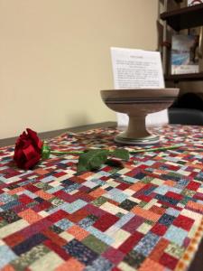 een quilt op een tafel met een rode roos erop bij Caravaggio Apartment in Napels