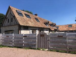 a barn with a wooden fence in front of it at La Chapelle de Monet - Logis Jasmin in Bois-Jérôme-Saint-Ouen