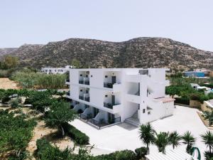 an aerial view of a white building with a mountain in the background at Elea Terra Hotel in Matala