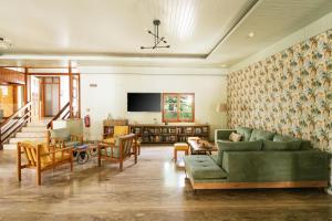 a living room with a couch and a tv at Elea Terra Hotel in Matala