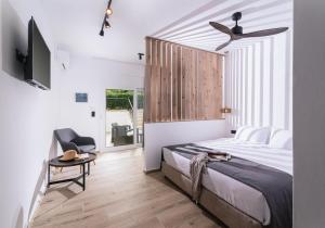 a bedroom with a bed and a ceiling fan at Elea Terra Hotel in Matala +173 photos