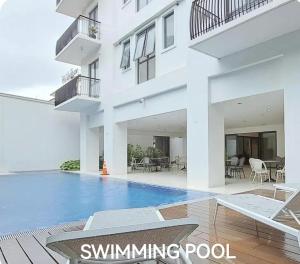 a swimming pool in front of a white building at Debbie's Modern 1 BR Condo Unit in Batangas City