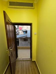 an open door to a room with a yellow wall at Sweet dream house in Zanzibar City