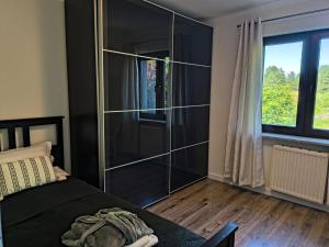 a bedroom with a bed and a large glass closet at Dom Nad Jeziorem 