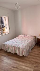 a bedroom with a bed with a pink blanket on it at Casinha do mar in Buarcos