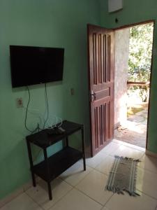 a living room with a television on a green wall at The village flats in Trindade