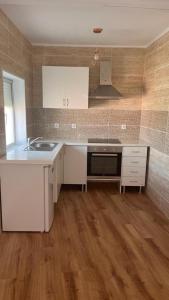 a kitchen with white cabinets and a sink at Casinha do mar in Buarcos