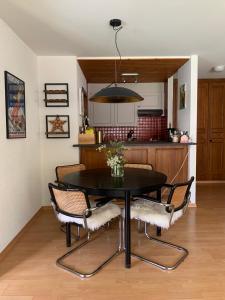 a dining room table and chairs in a kitchen at Charmant appartement, hyper central, à 2 min de tout, énorme terrasse privée et parking couvert in Crans-Montana